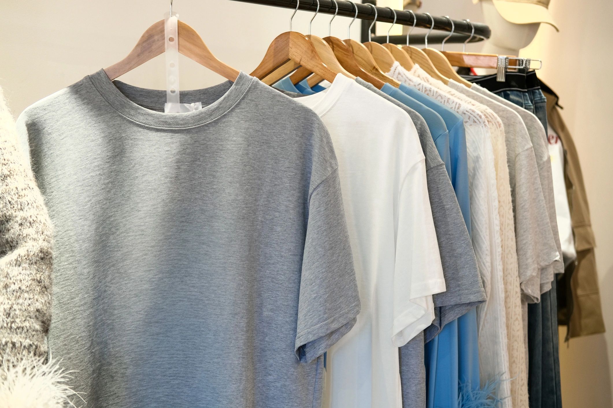 Casual T-shirts displayed on hangers in a boutique clothing store